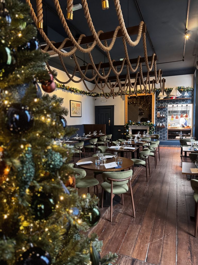 The Barnacle restaurant, featuring a beautifully decorated Christmas tree with twinkling lights and baubles